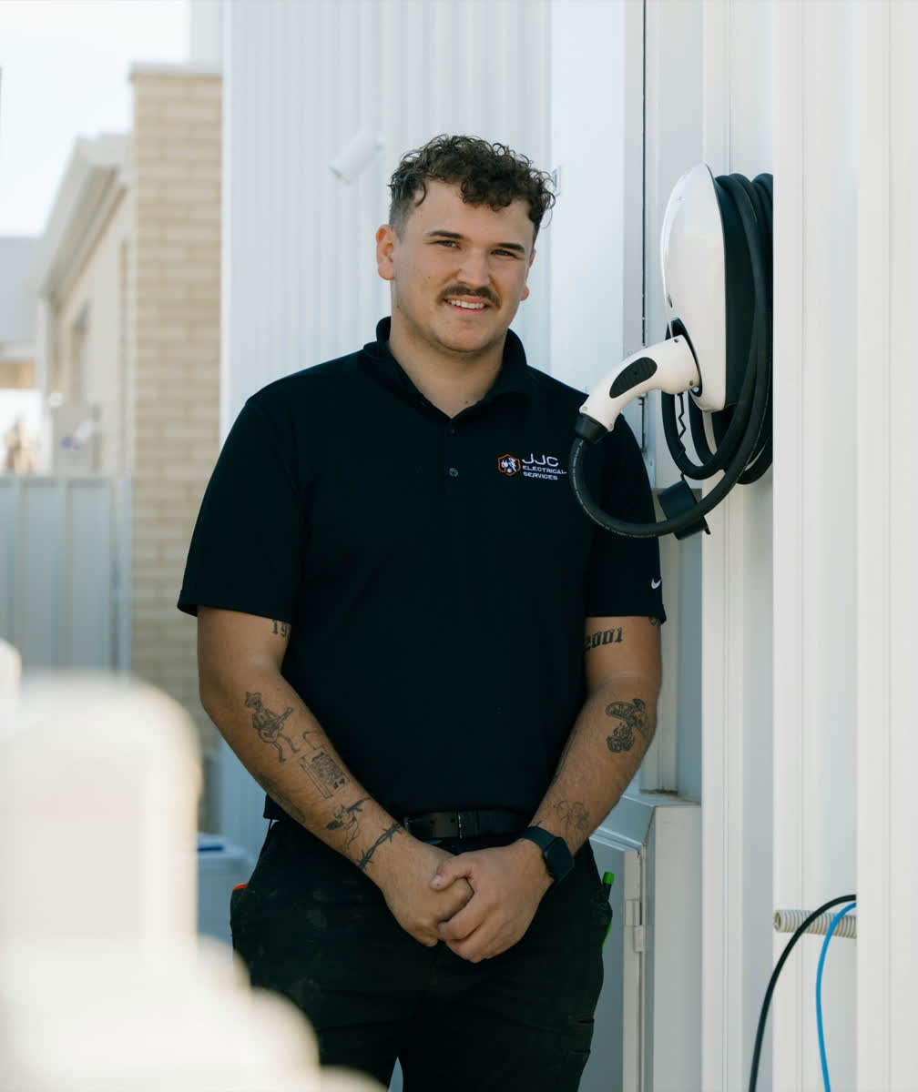 James from JJC Electrical beside an EV charger he installed