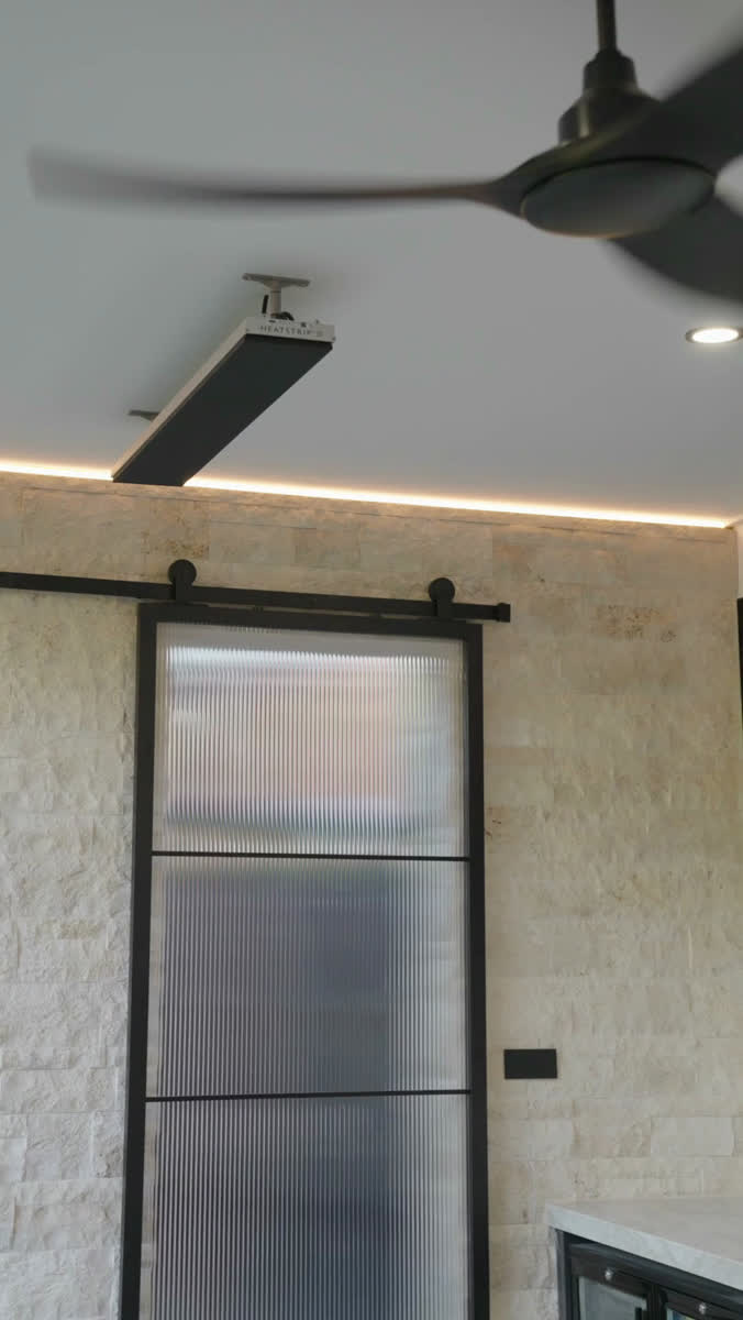 A ceiling fan and a strip heater in a newly finished room