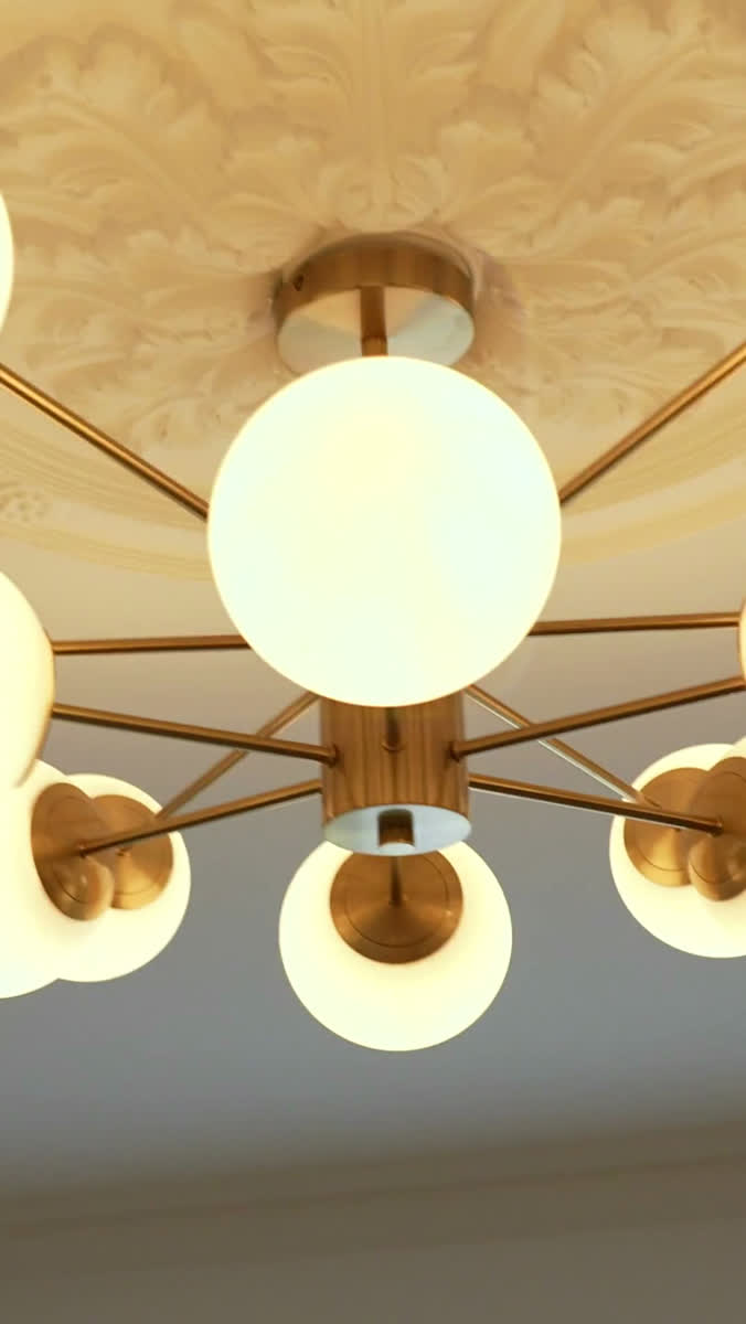 A gold chandelier with glass globe lights